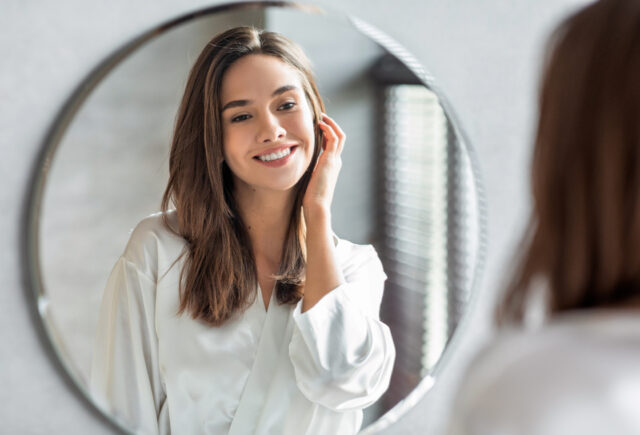 Young woman looking at herself in mirror